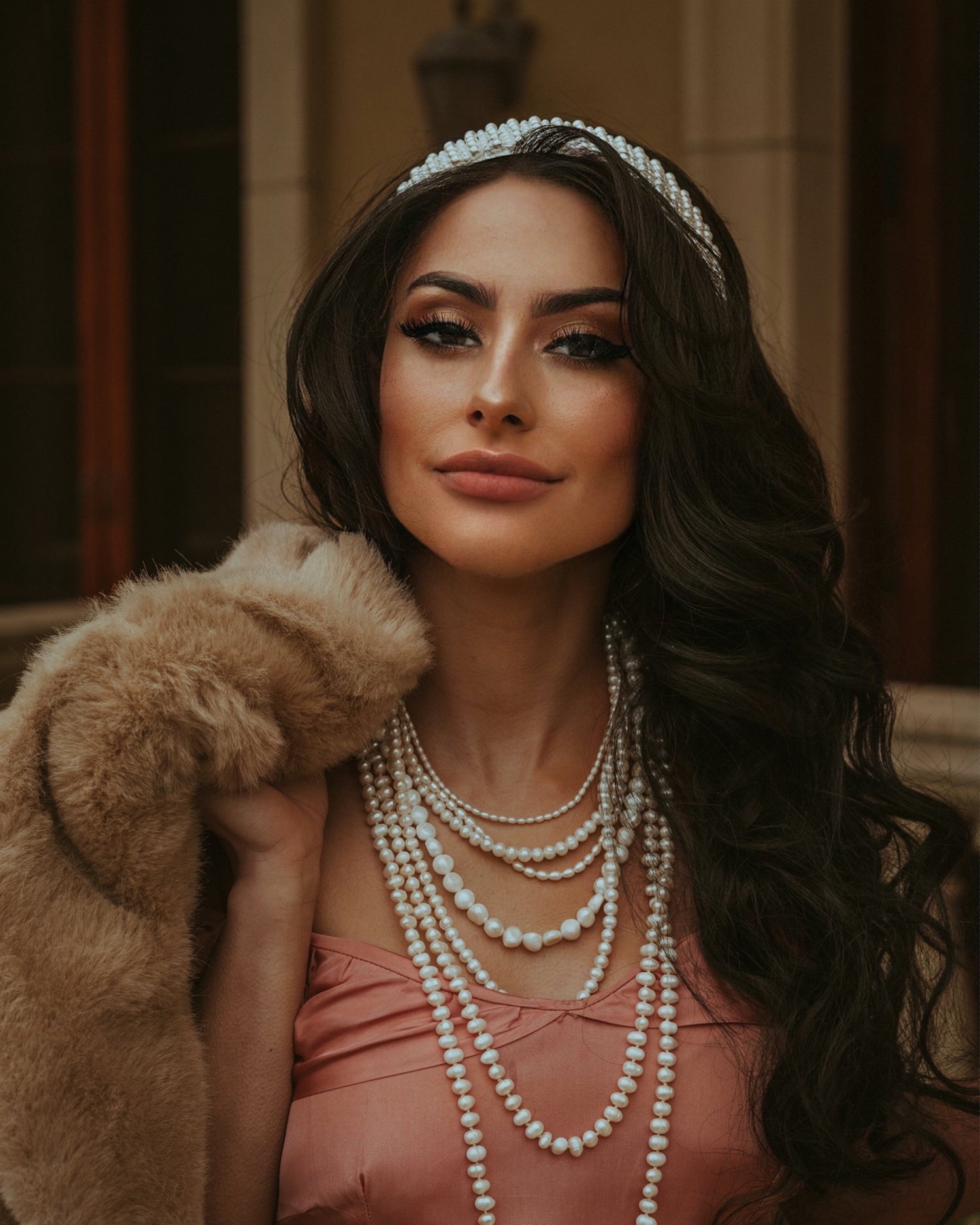 Stylish woman wearing luxury fur coat, affordable white pearl necklace and chain, shiny diamond tiara with sparkling cubic zirconia stones;